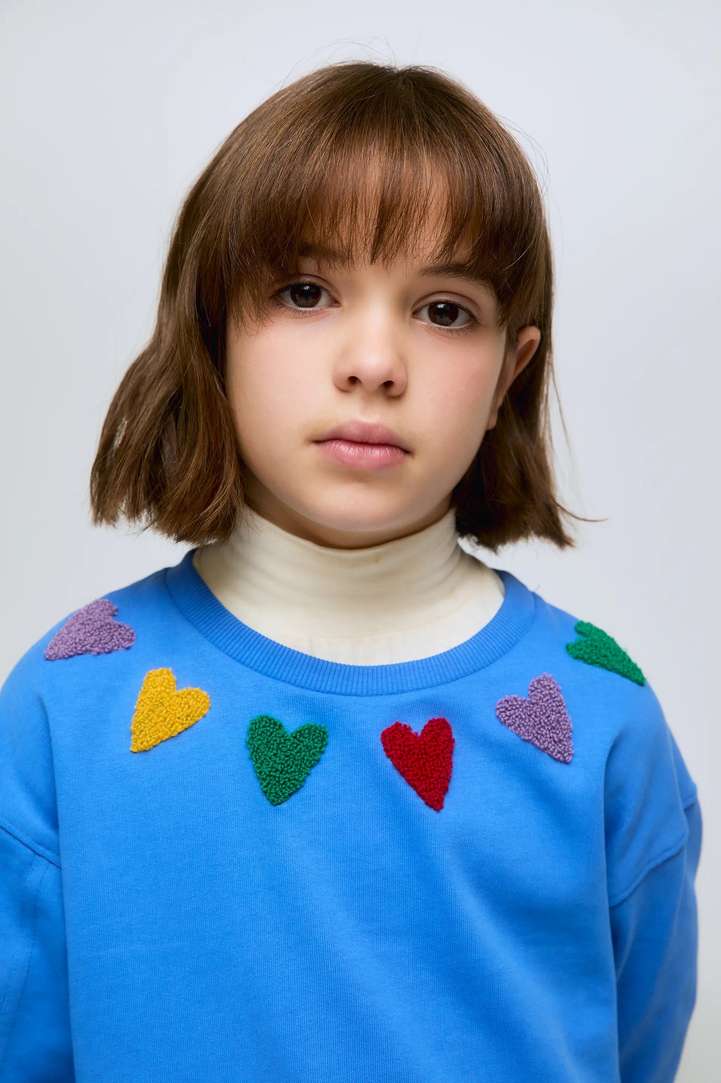 Blue sweatshirt with embroidered heart details.