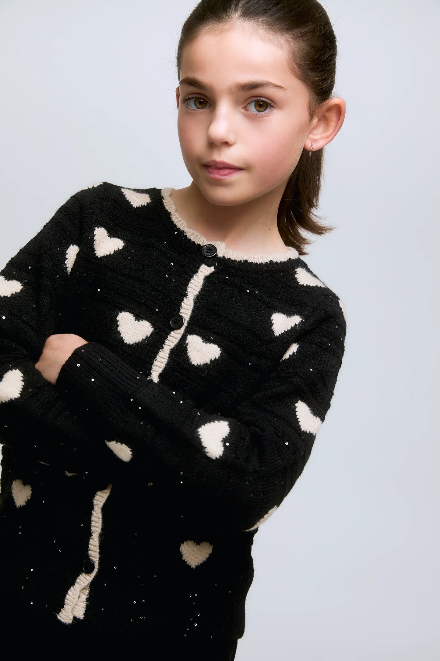 Black girl's cardigan with white hearts and front buttons.