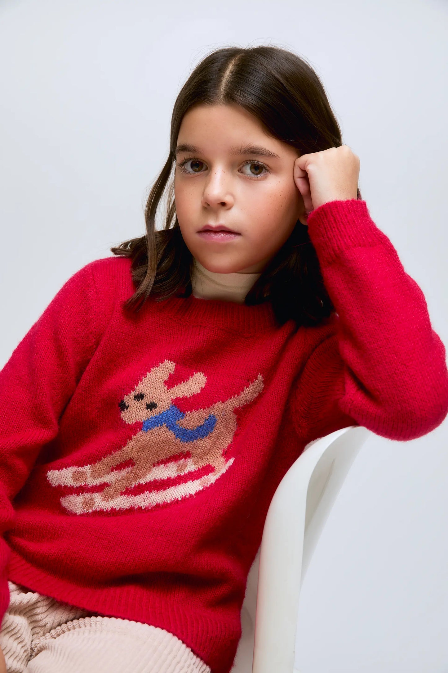 Red knitted sweater with a skiing dog design.