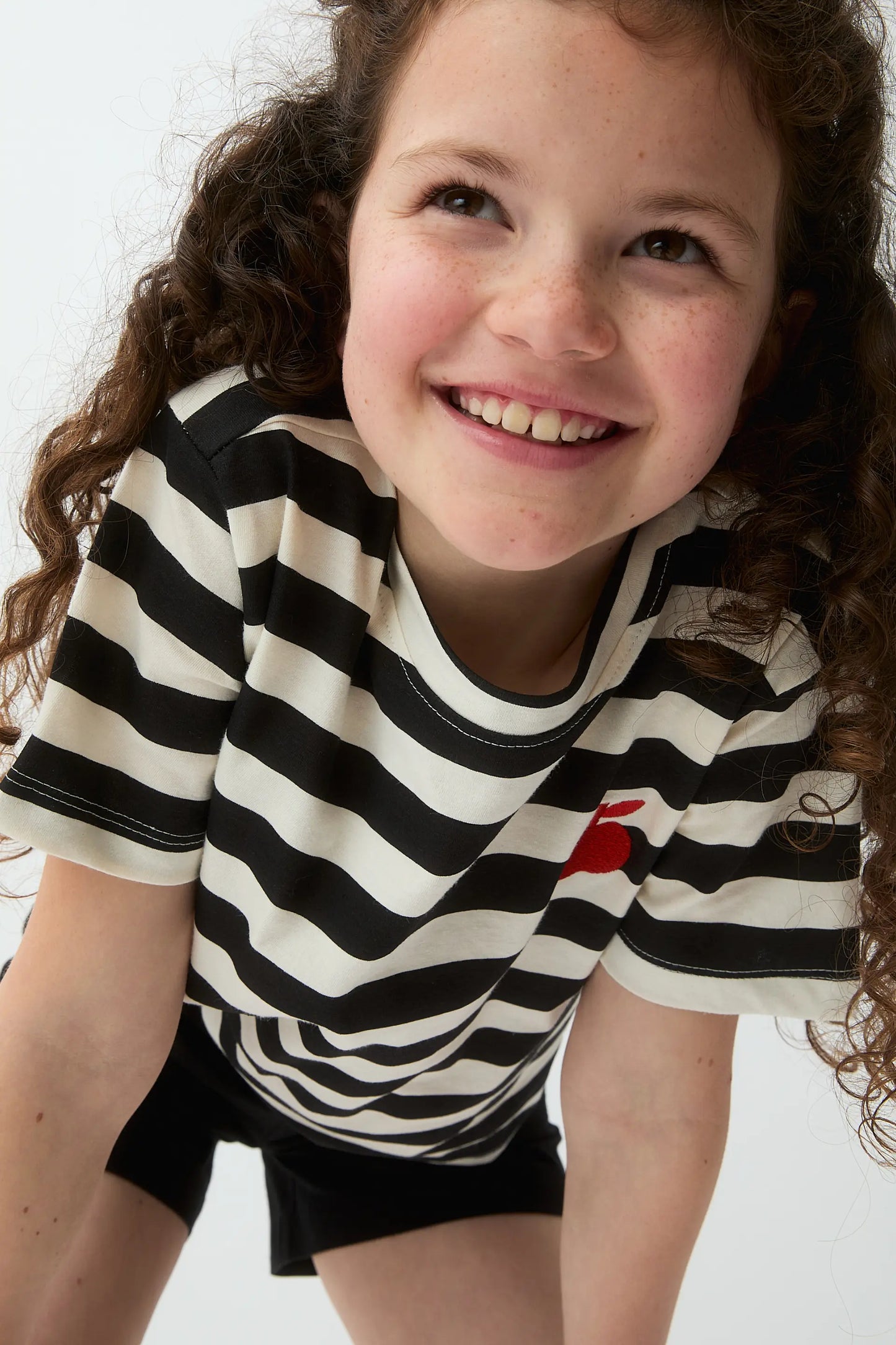 Camiseta de niña con estampado de rayas negras y bordado de manzana