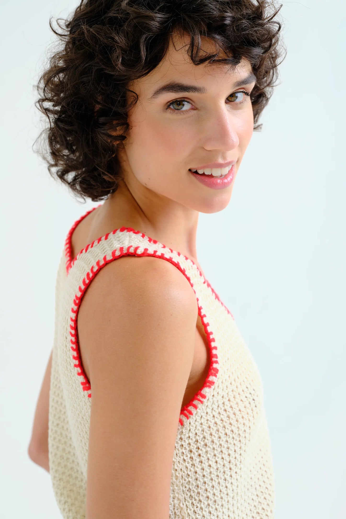 Off-white openwork knit top with red embroidered details