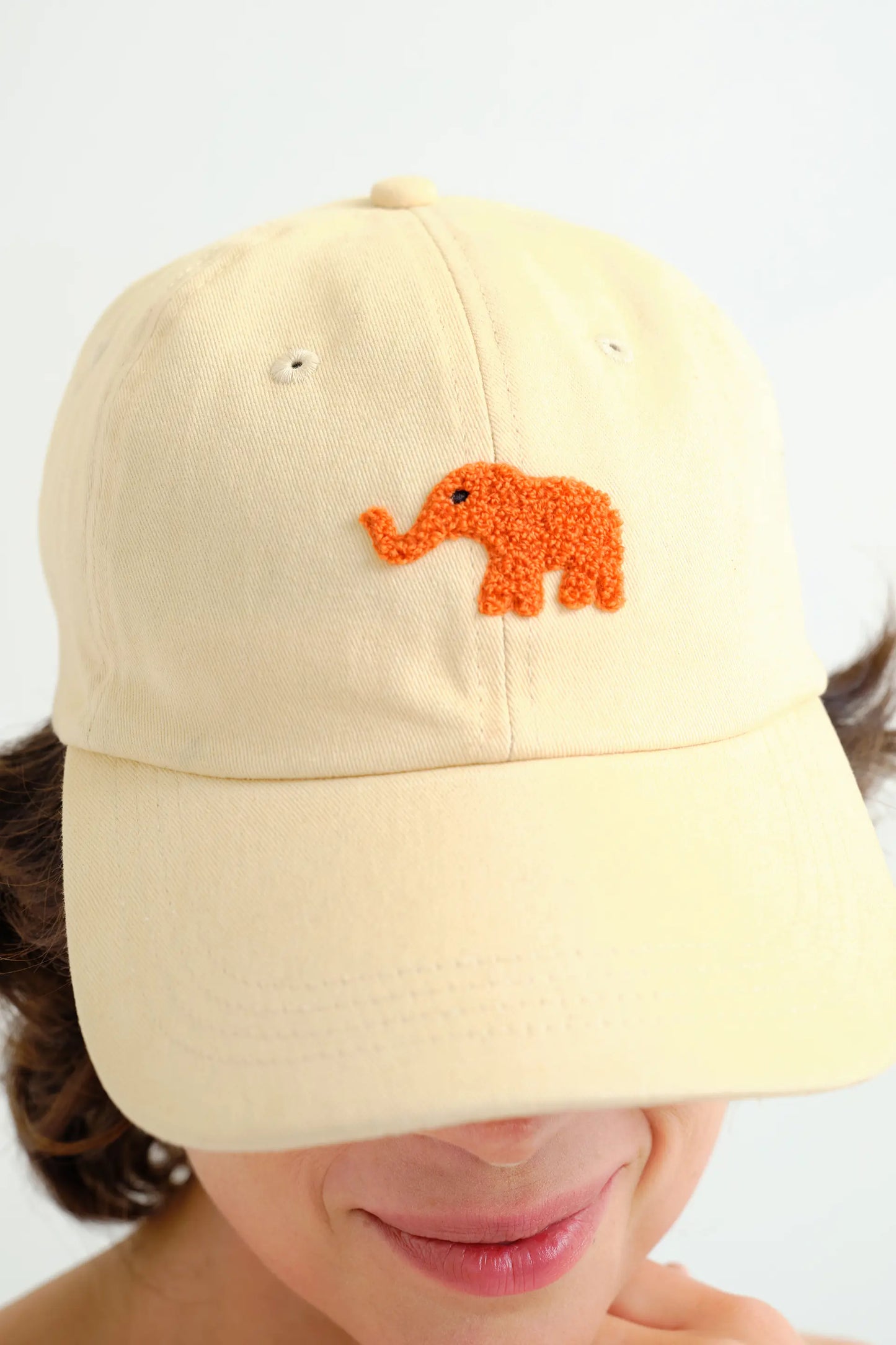Gorra beige con bordado de elefante rojo