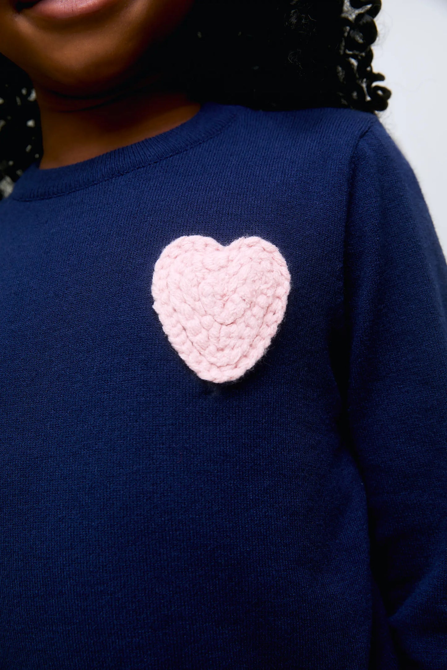 Navy blue knitted girl's sweater with pink heart embroidery