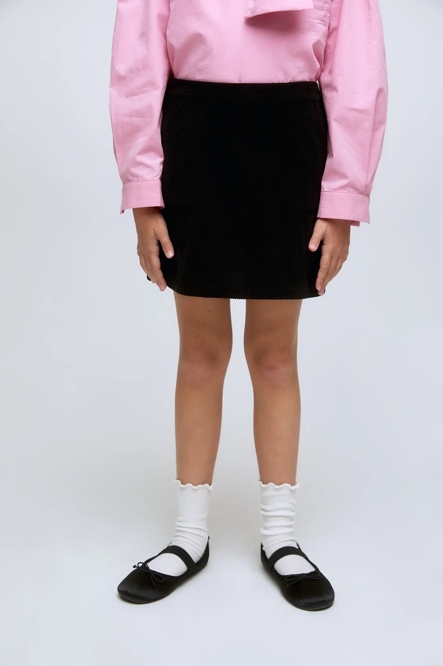 Falda corta de niña de pana en color negro canalé.