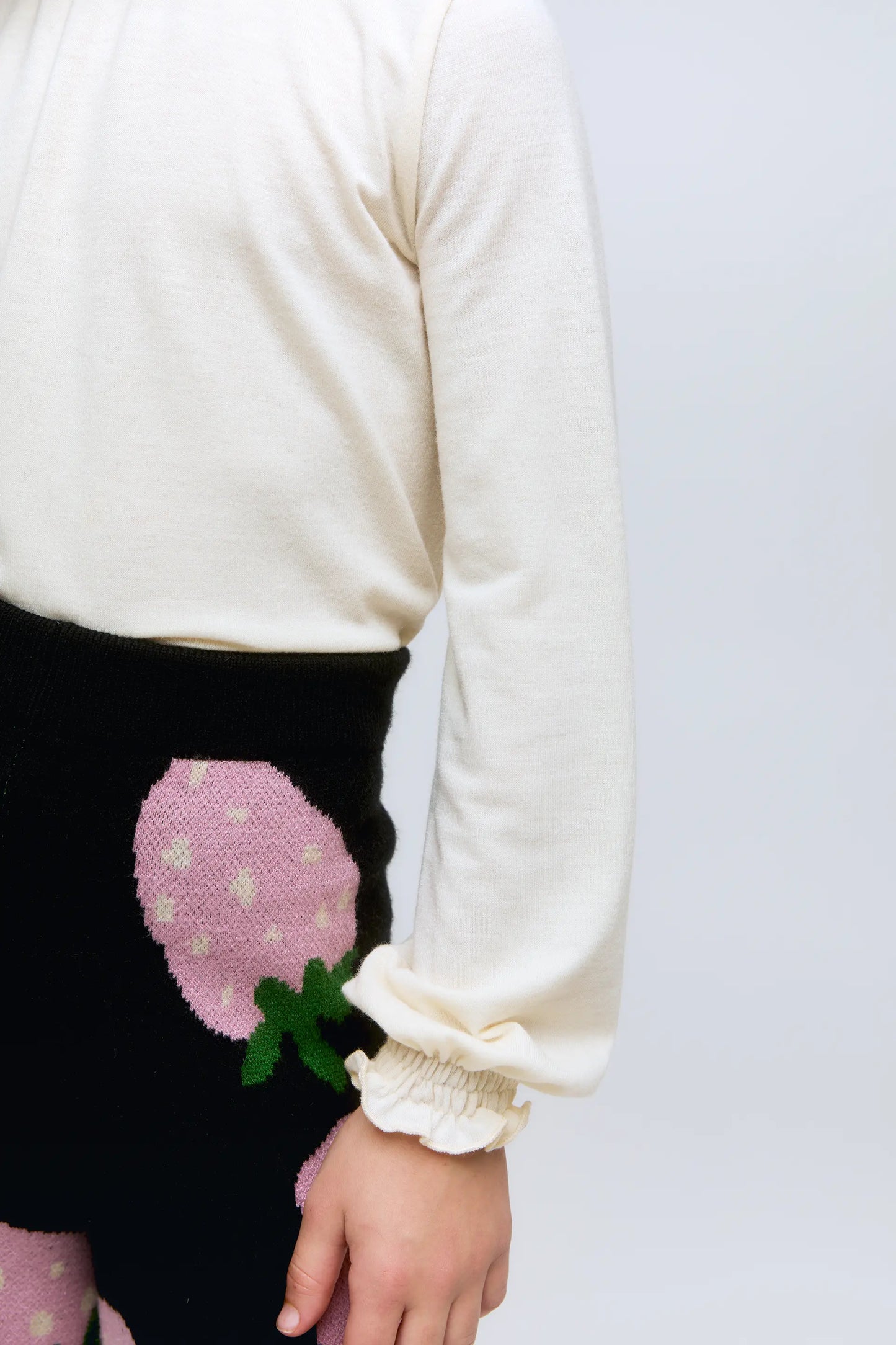 Maglione bianco da bambina a collo alto con polsini arricciati