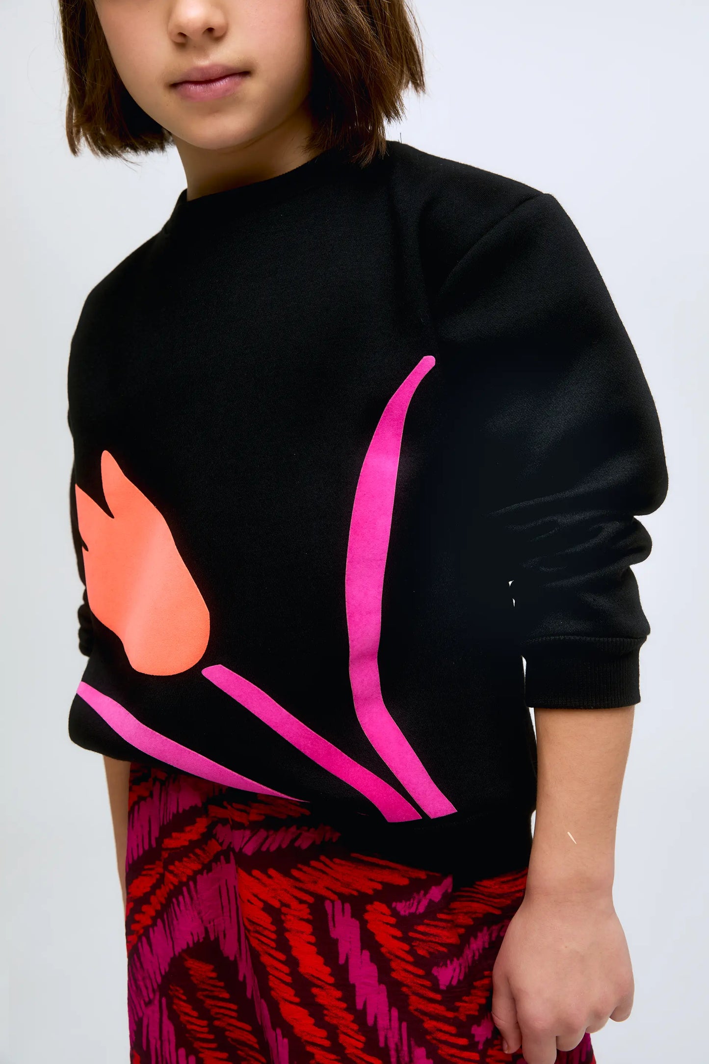 Sudadera en color negro con estampado gráfico de flor en contraste.