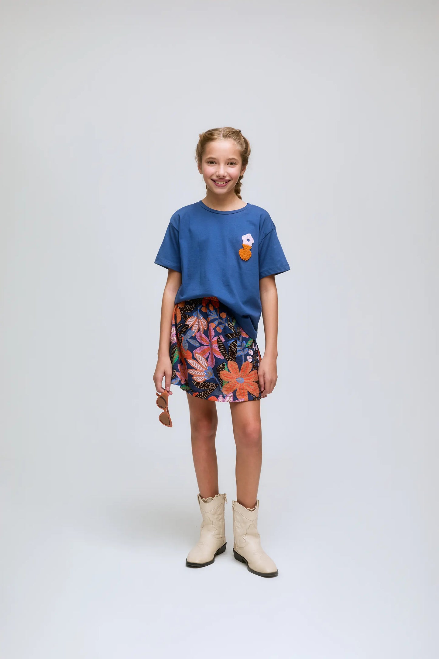 Maglietta blu da bambina con ricami floreali.