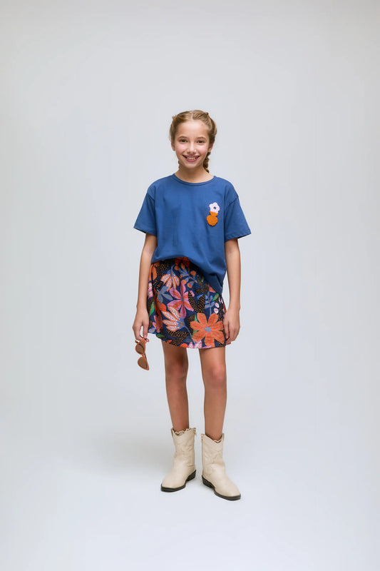 Camiseta azul de niña con bordado de flor.