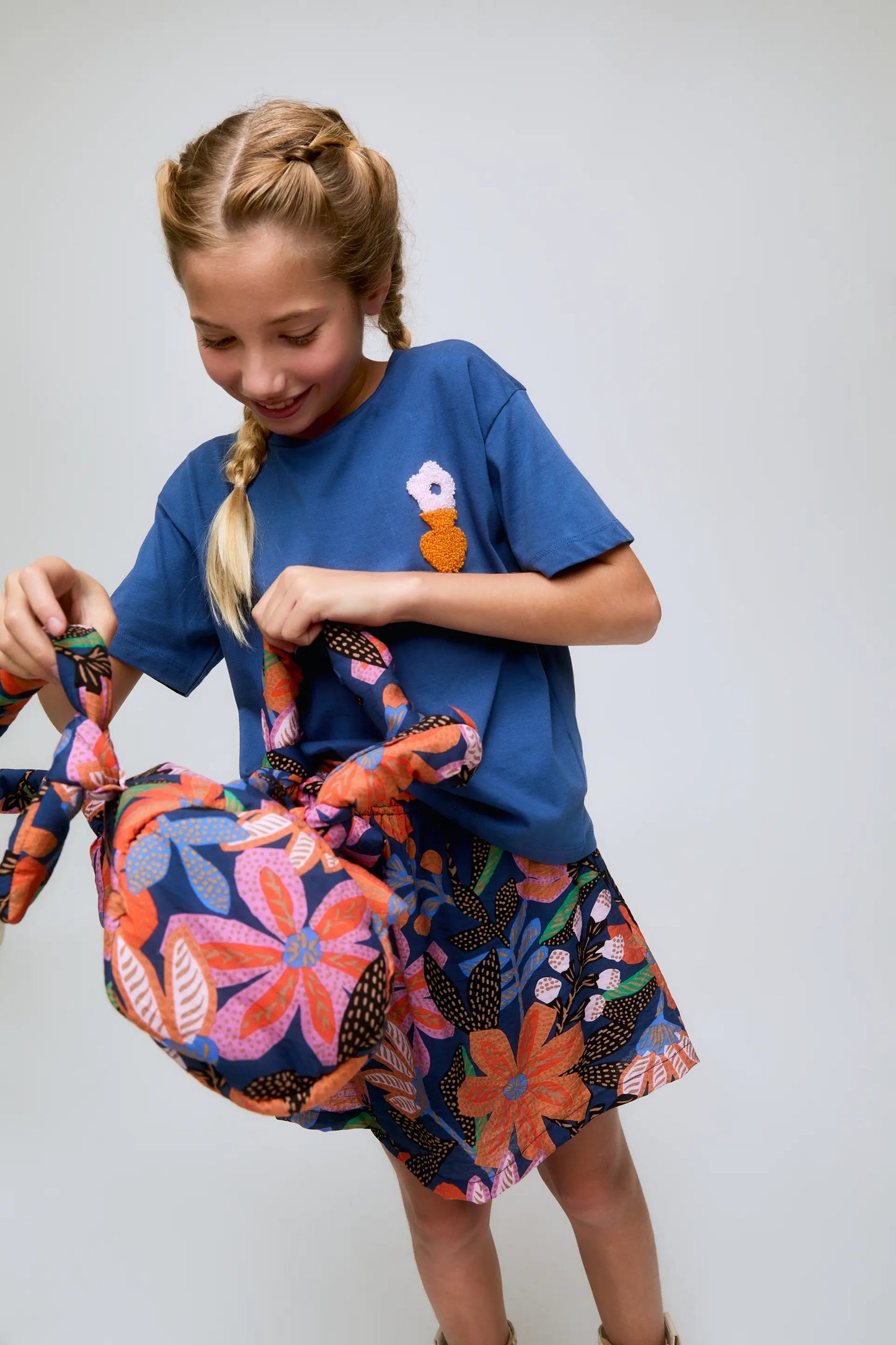 Maglietta blu da bambina con ricami floreali.