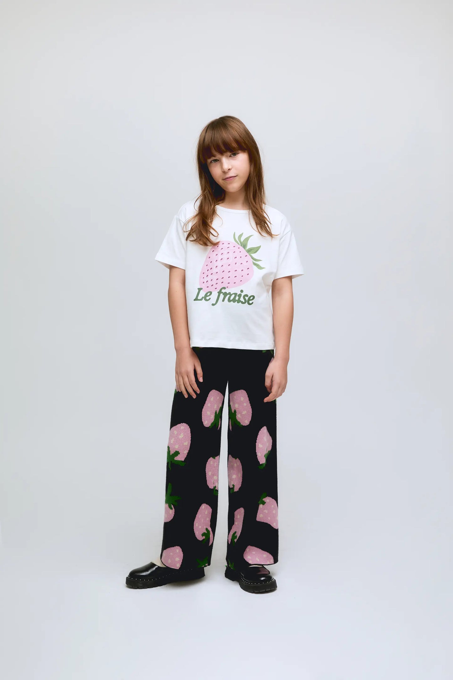 Maglietta bianca a maniche corte da bambina con stampa di fragole.