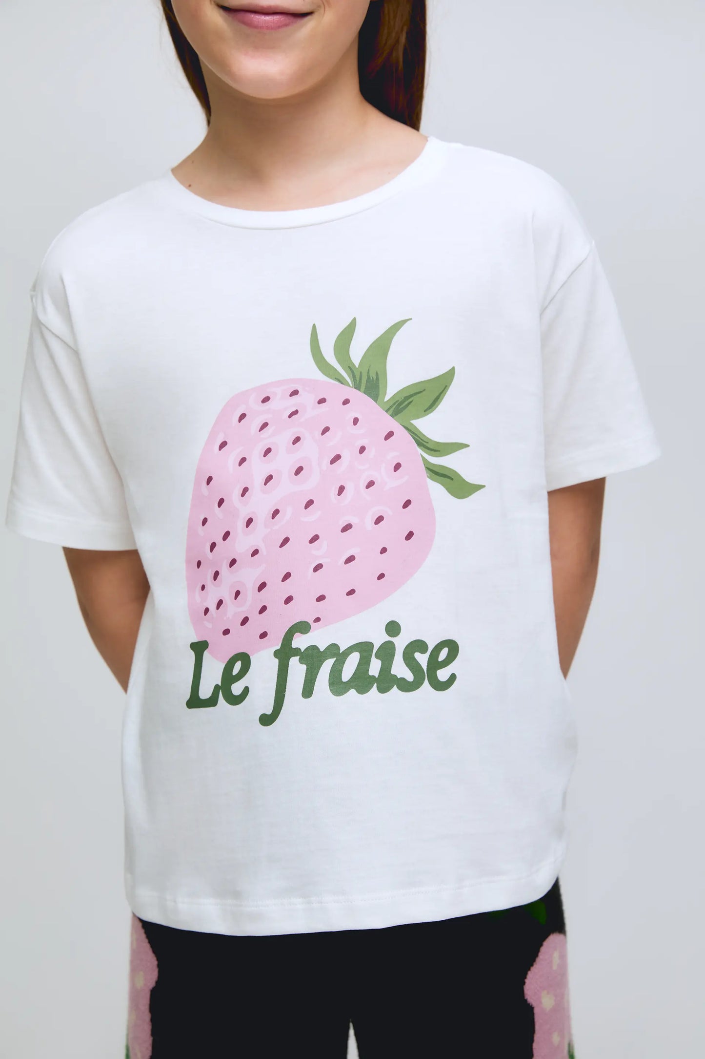 Maglietta bianca a maniche corte da bambina con stampa di fragole.