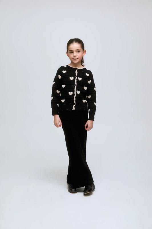 Cárdigan de niña negro con corazones blancos y botones frontales.