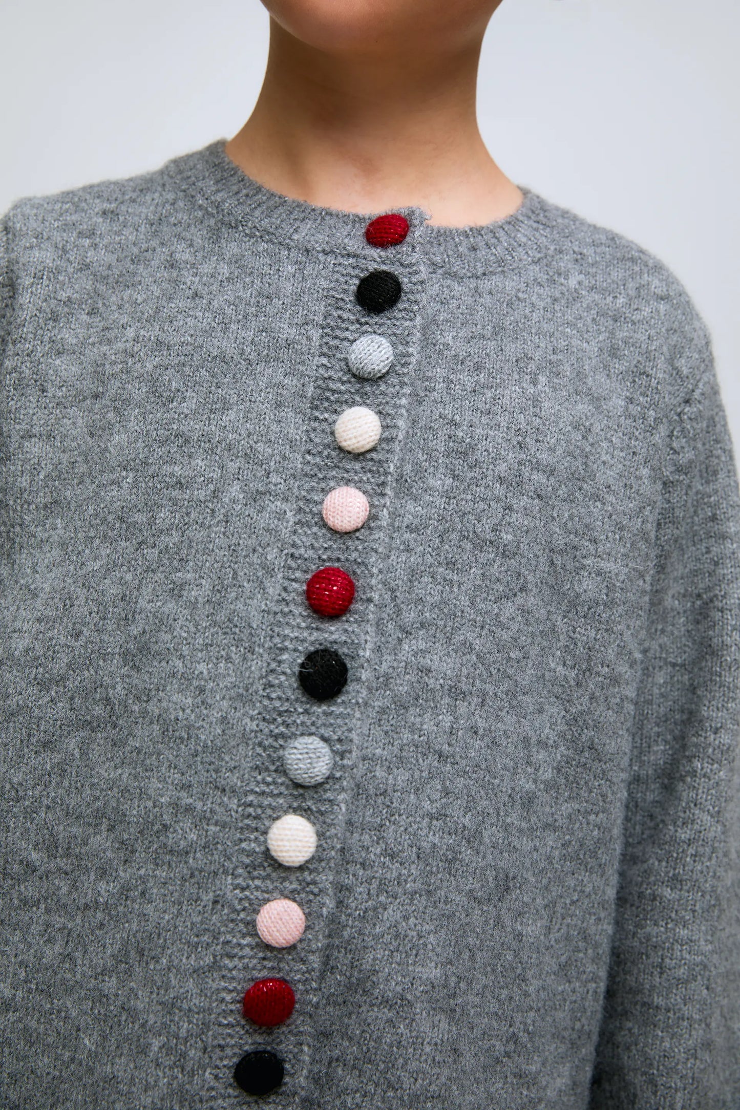 Grey girl's cardigan with round neck and buttons.