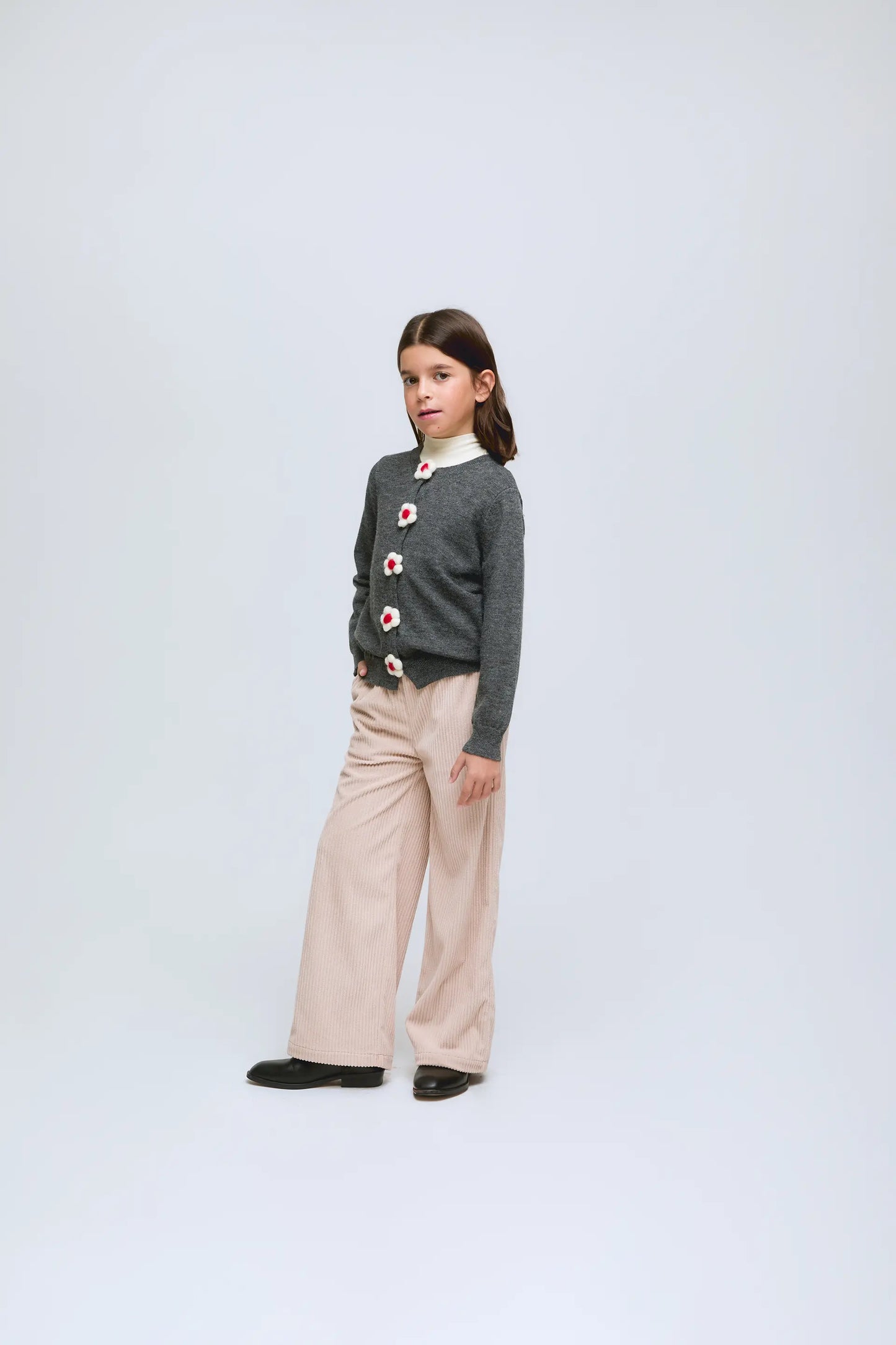 Cardigan gris de punto con botones en forma de flor.