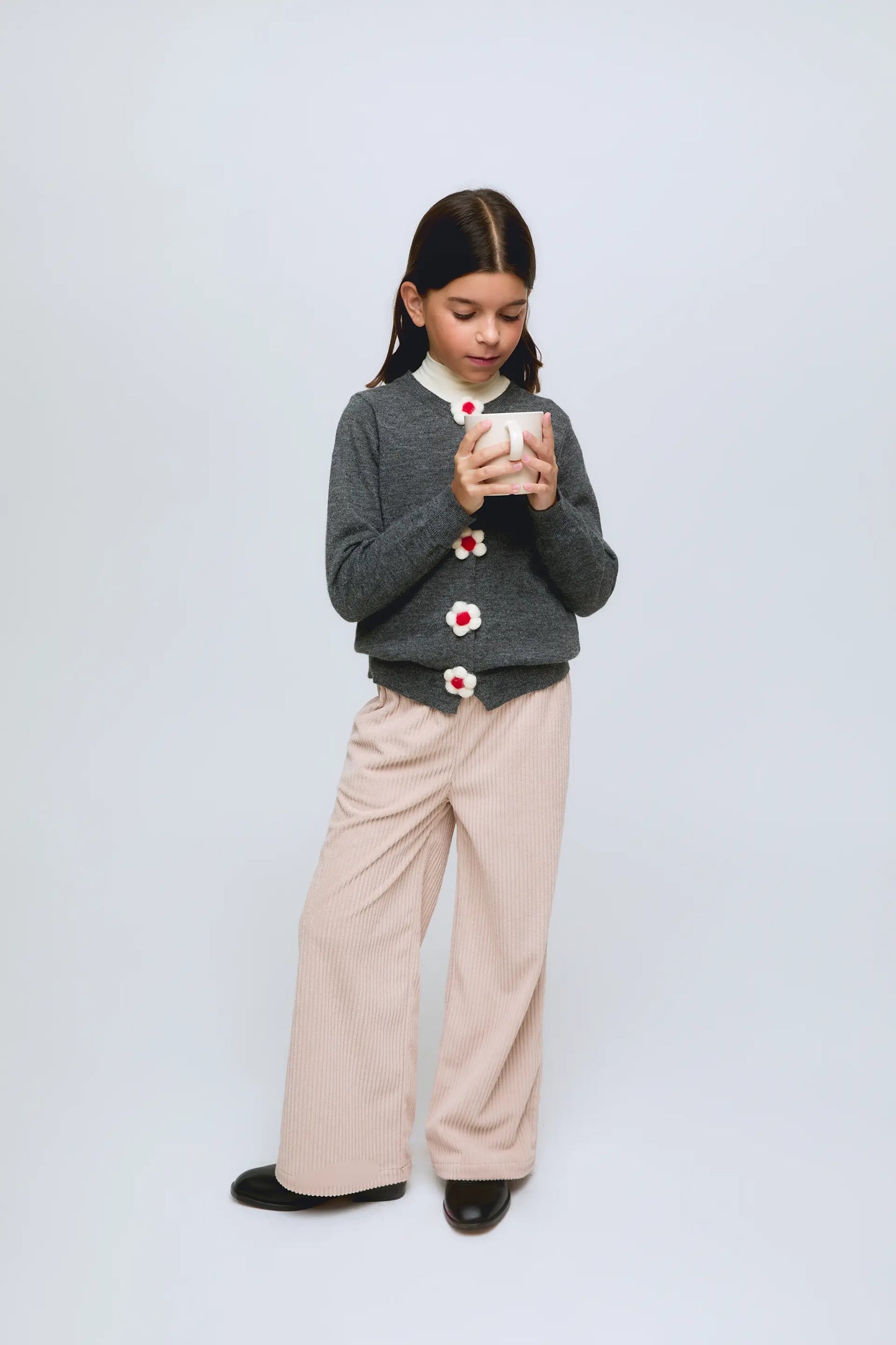 Cardigan gris de punto con botones en forma de flor.