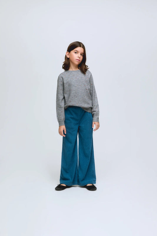 Jersey de niña de punto gris con pequeños apliques de brillos.