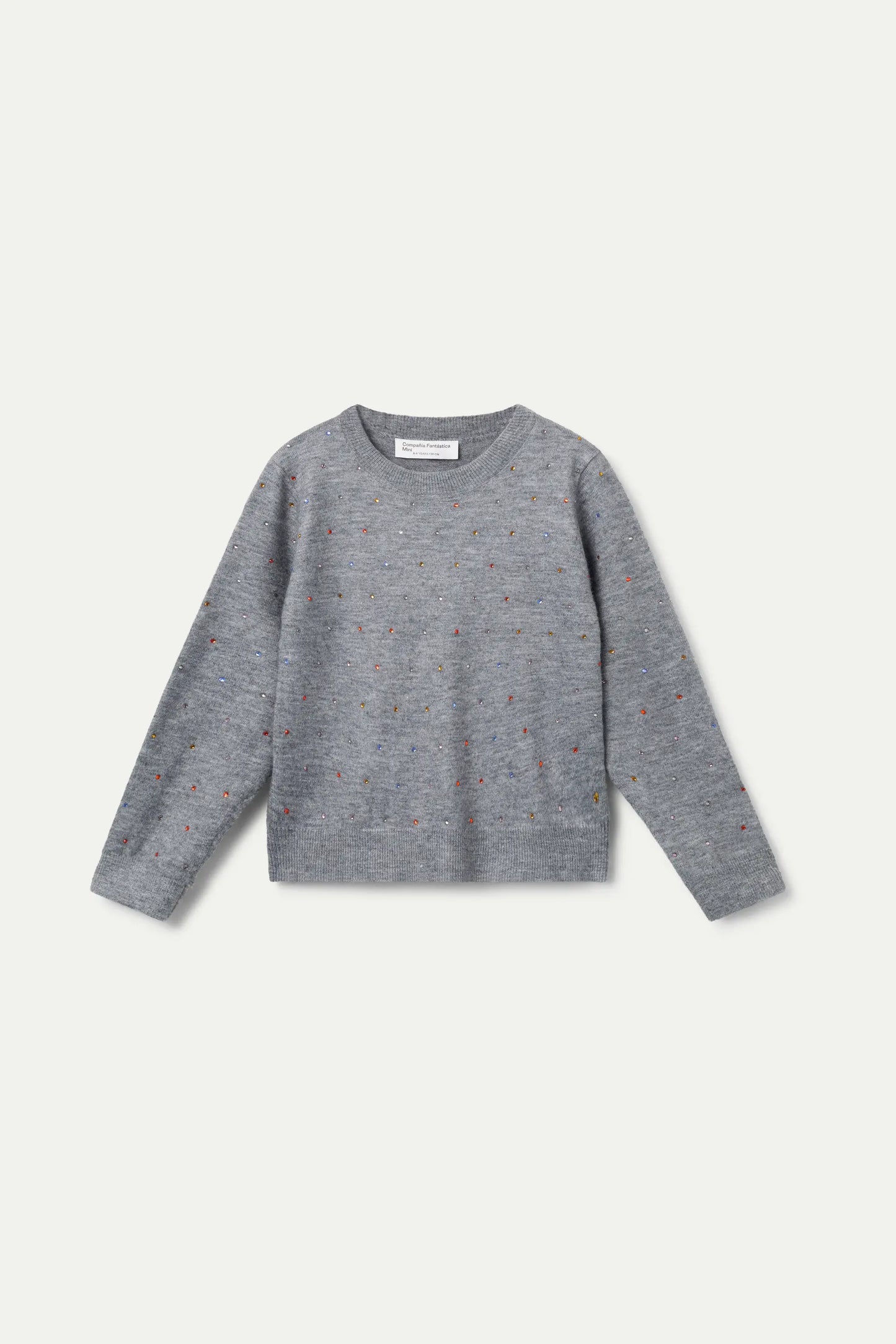 Grey knitted girl's sweater with small glitter appliqués.