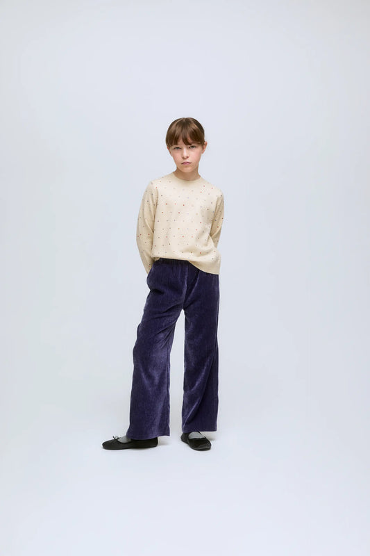 Jersey de niña de punto beige con pequeños apliques de brillos.