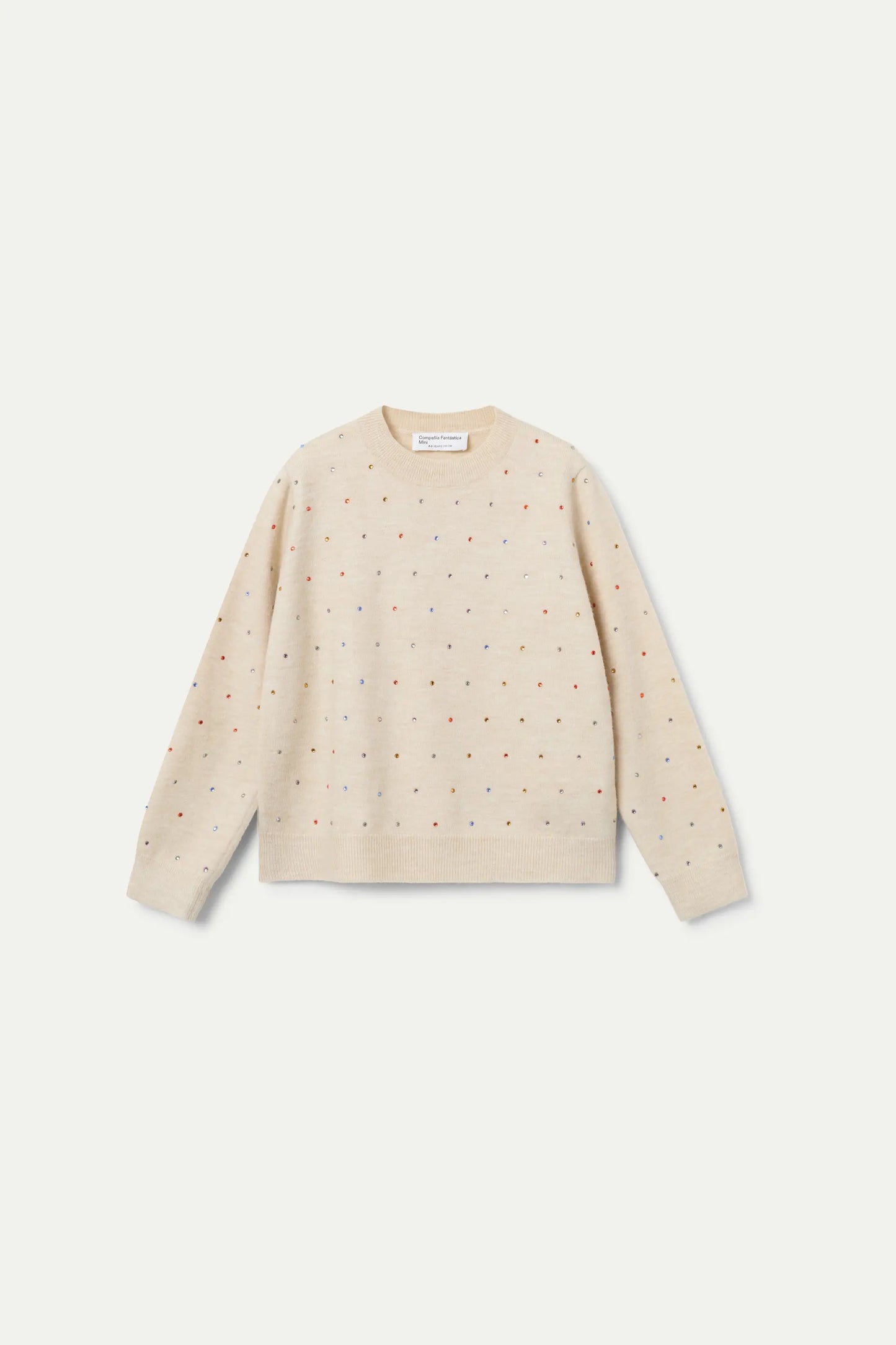Beige knitted girl's sweater with small glitter appliqués.
