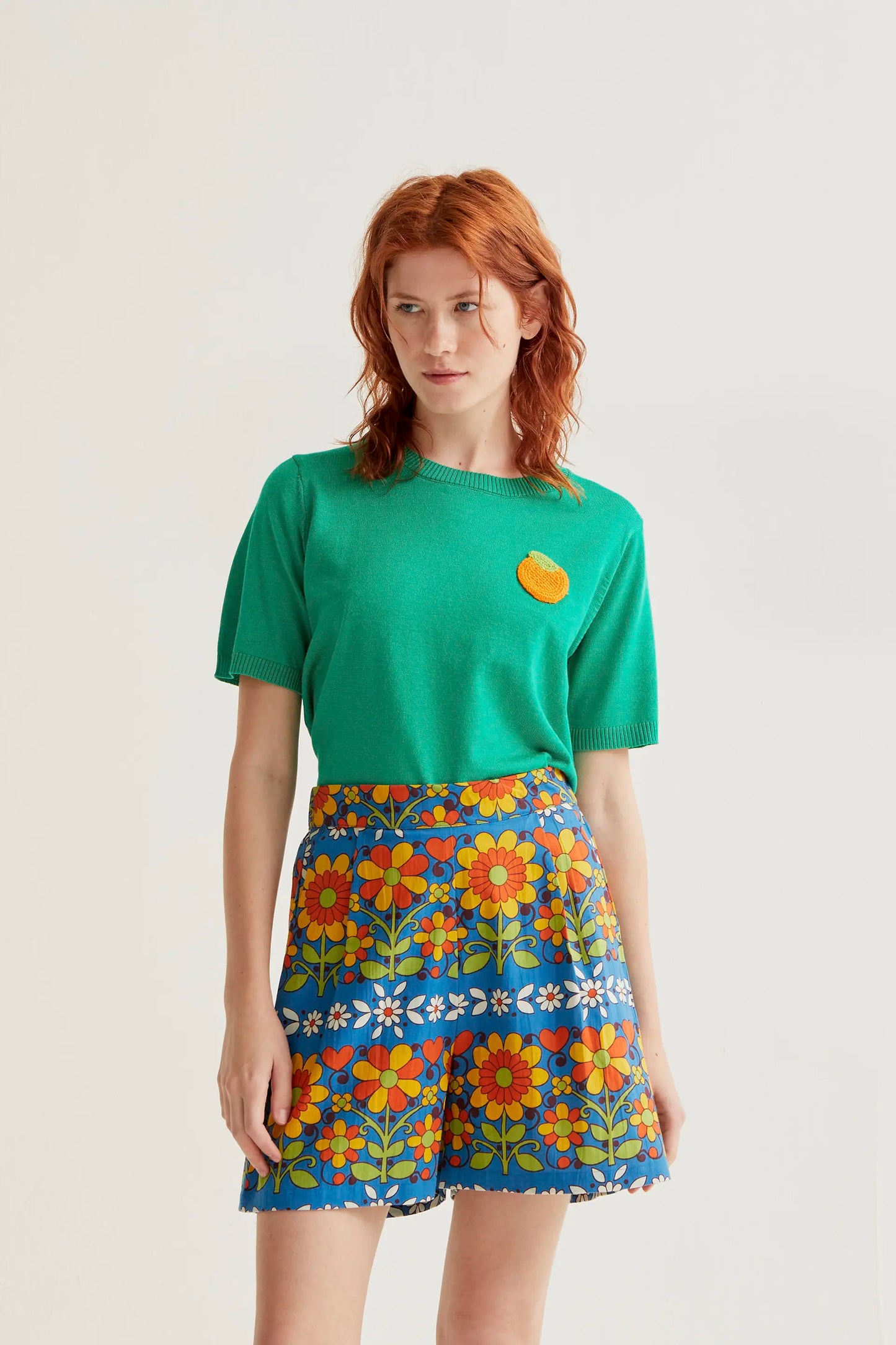 Top de punto verde con bordado de naranja