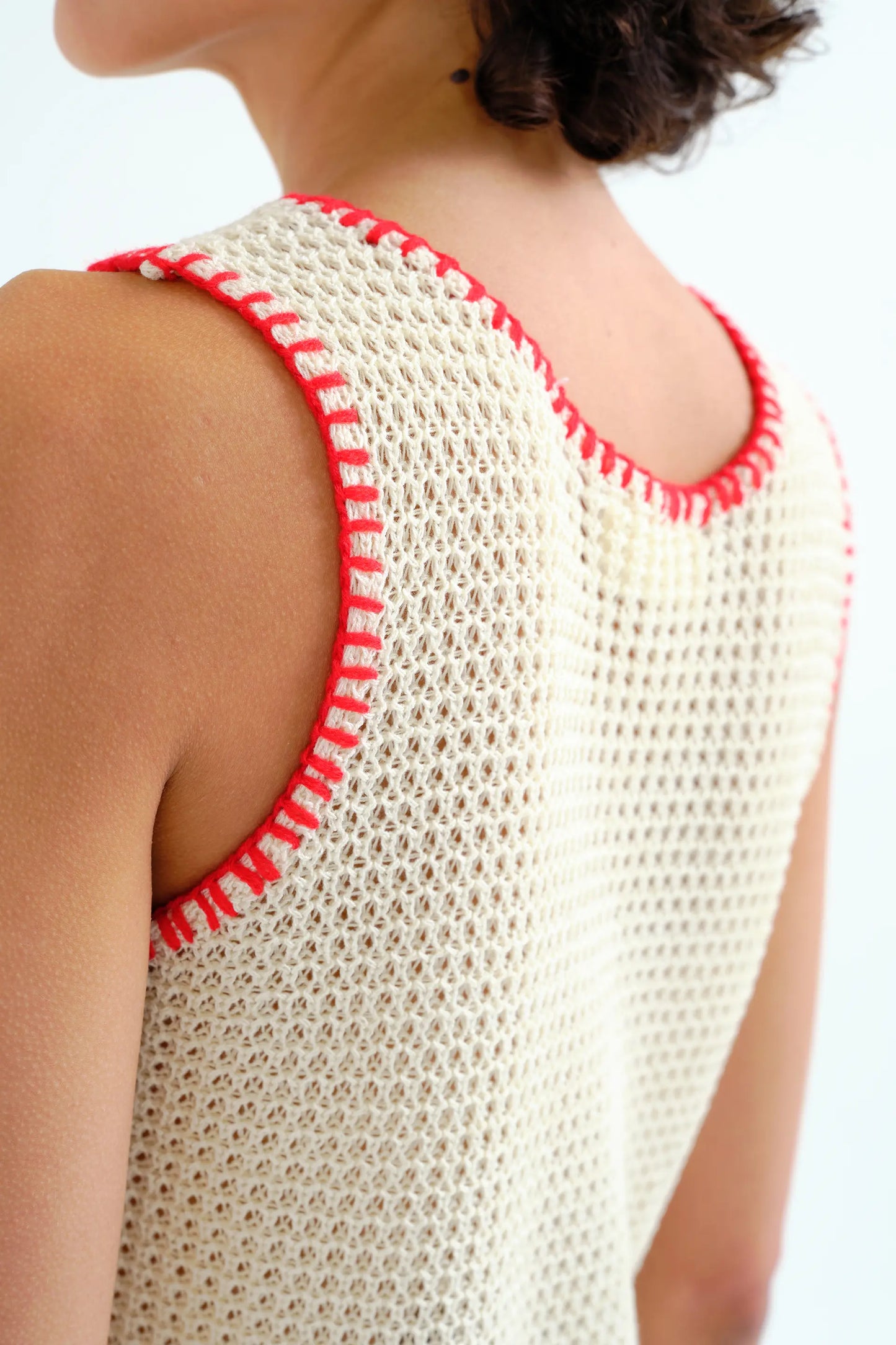 Off-white openwork knit top with red embroidered details
