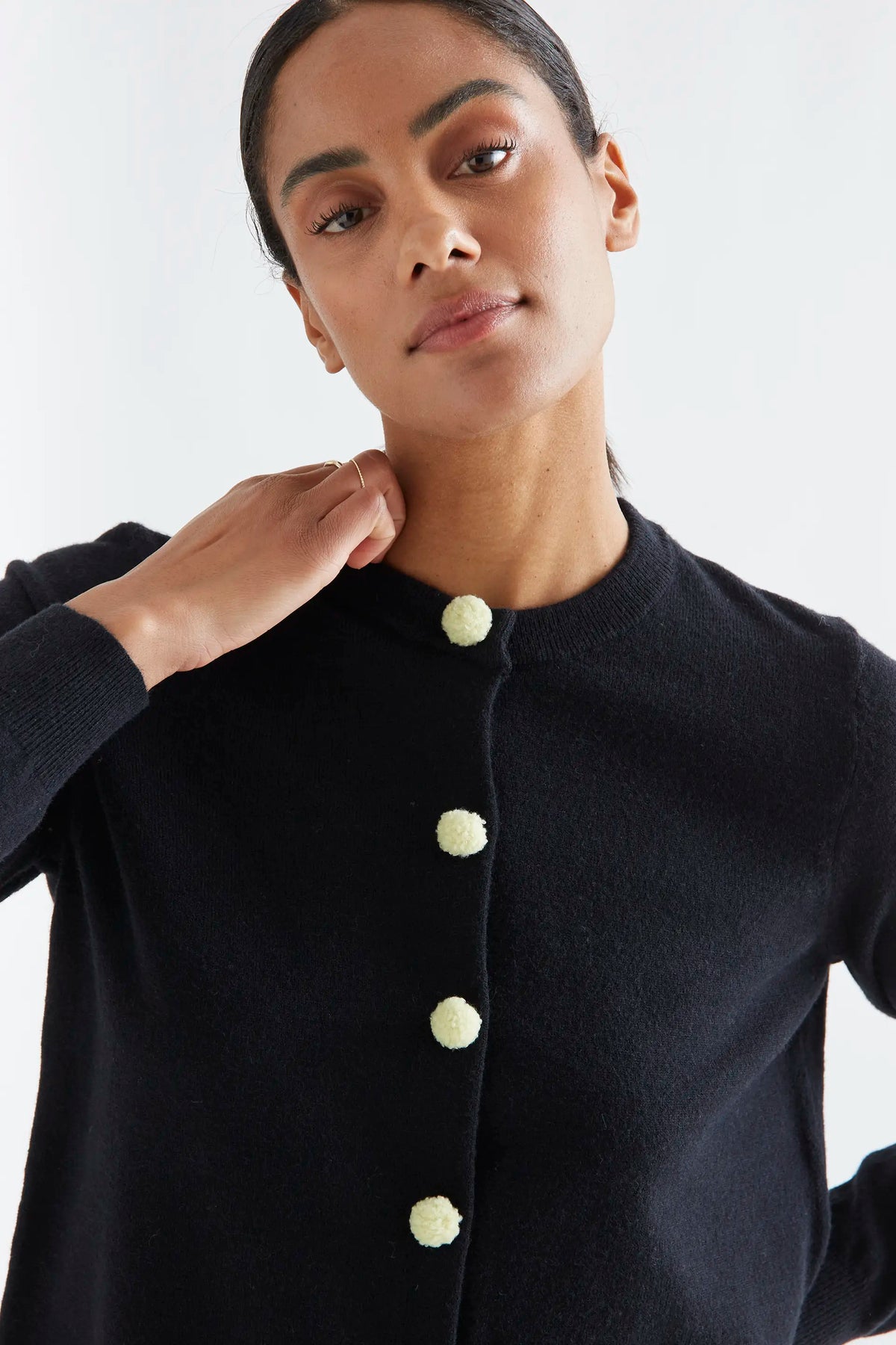 Black cardigan with white pompoms