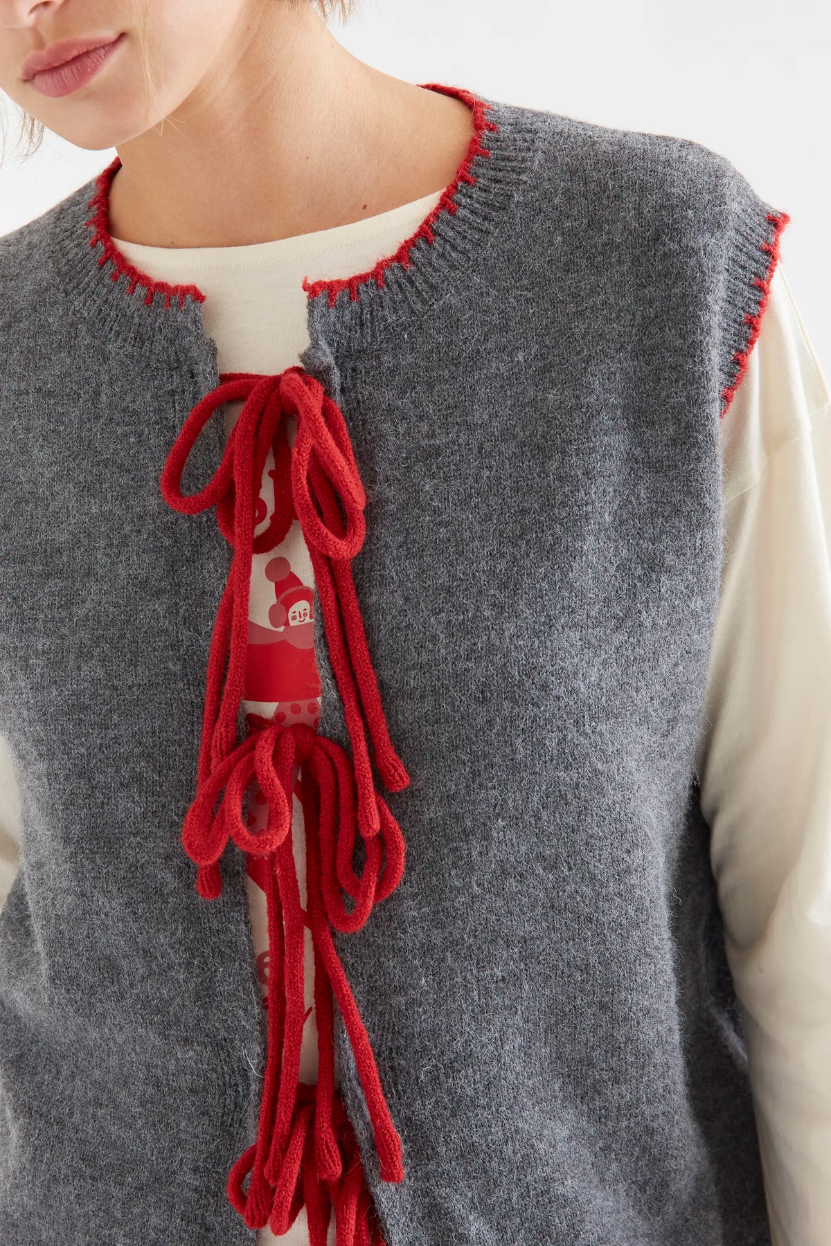 Chaleco punto gris con detalle lazado rojo