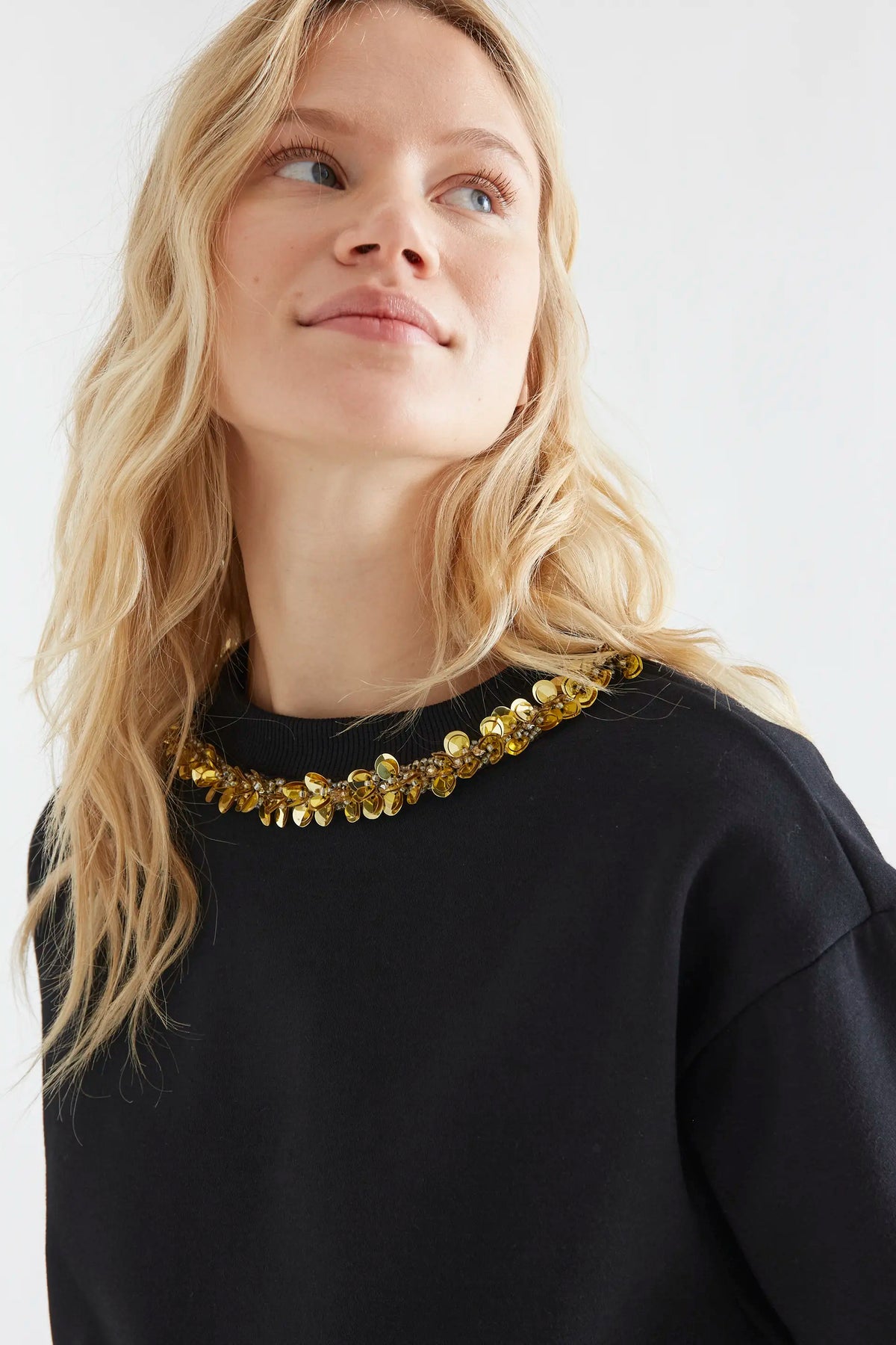 Sudadera negra con cuello joya dorado