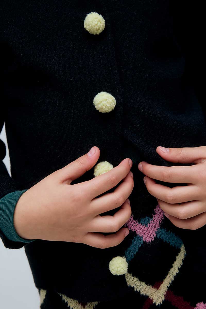 Cardigan nero da bambina con bottoni a pompon