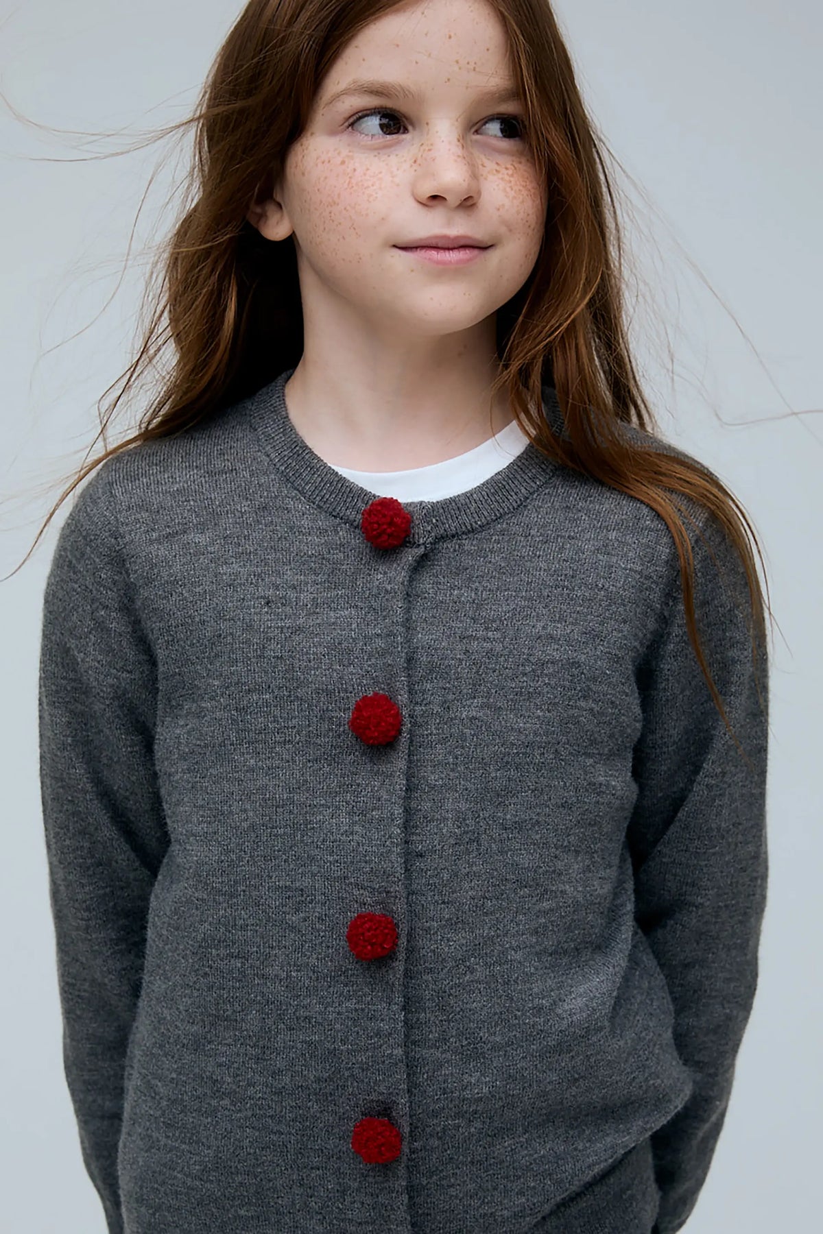 Cárdigan negro de niña gris con botones de pompones